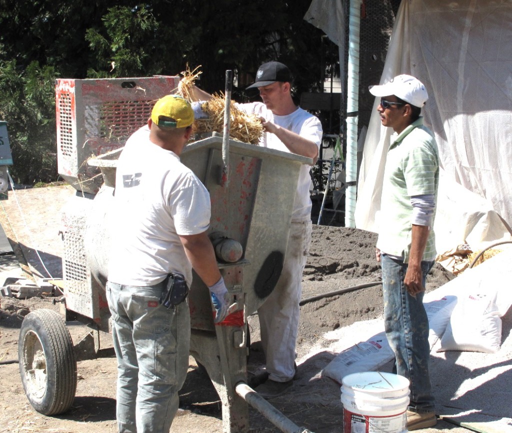 David Kaiser Jr. and his crew begin the initial mixing of lime, sand, clay, and straw to help bind the mix.