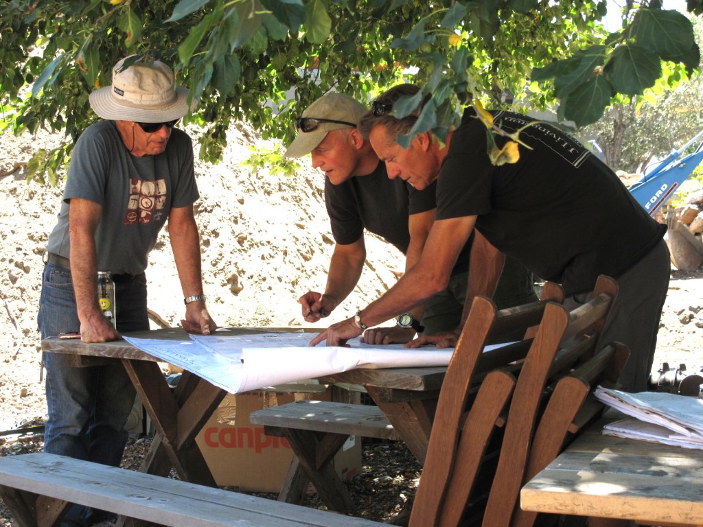 Patrick Fitzgerald, Principal Engineer with Whole Water Systems, Morgan Brown, President and Founder of Whole Water Systems, and James Fagan with Timberline, look over the wetland plans.
