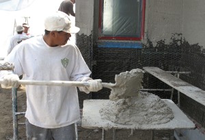 Victor loads the plaster mix ready for application to the wall.