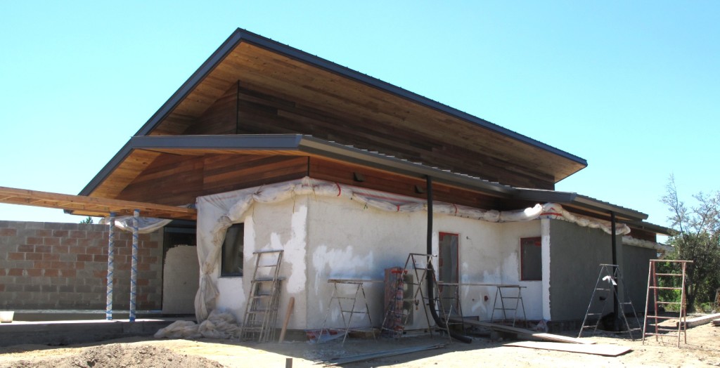 The north side of Desert Rain in various stages of plastering from second coat to final finish.