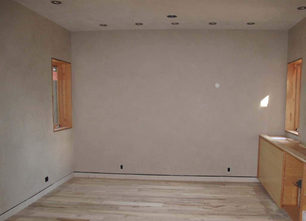 The den in the main house with American Clay wall covering, salvaged myrtlewood flooring, and LED lighting in place.