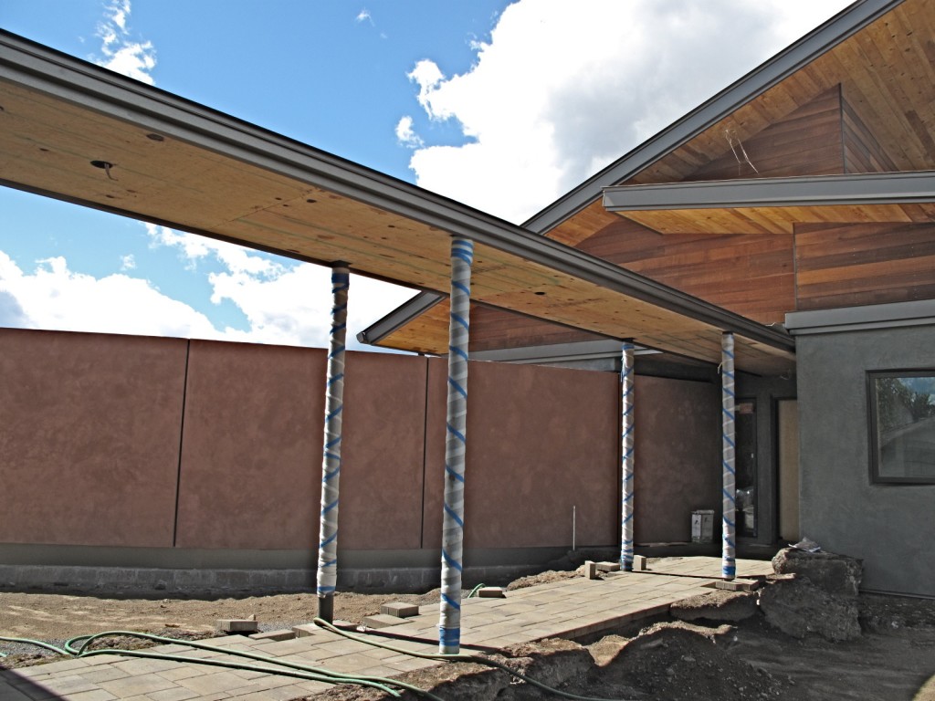 The covered walkway between the garage and the house with pavers and border stones in place. The 'Miro' wall is in the background.