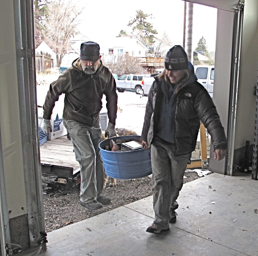 Tom and Anna carry the infamous 'blue bucket'. The bucket holds thousands of nails that were saved from the deconstruction of the original two houses. Barb hopes to see the nails used in an art project.