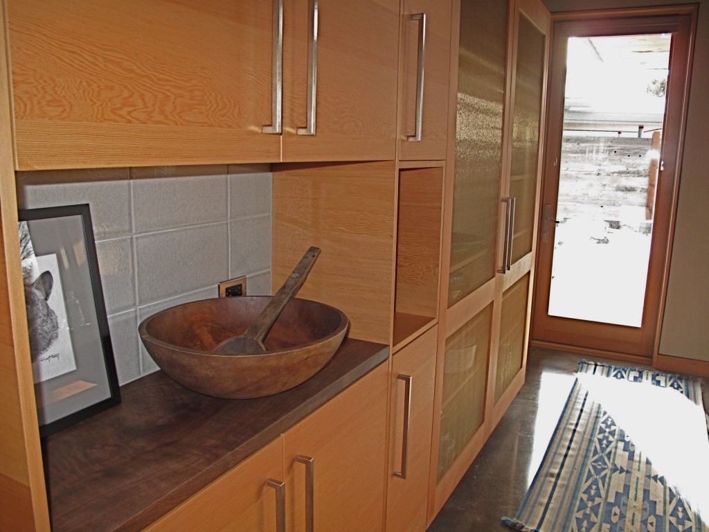 The beauty of the FSC wood cabinets, the salvaged walnut shelf, and a well-known salad bowl create 'home'.